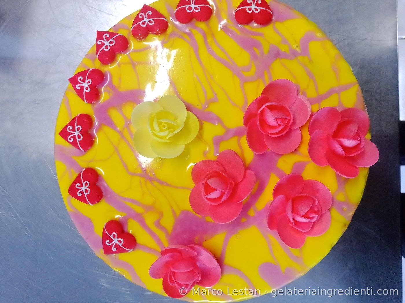 Decorazione torta gelato azzurra con schizzi gialli, macaron colorati e dischi di cioccolato