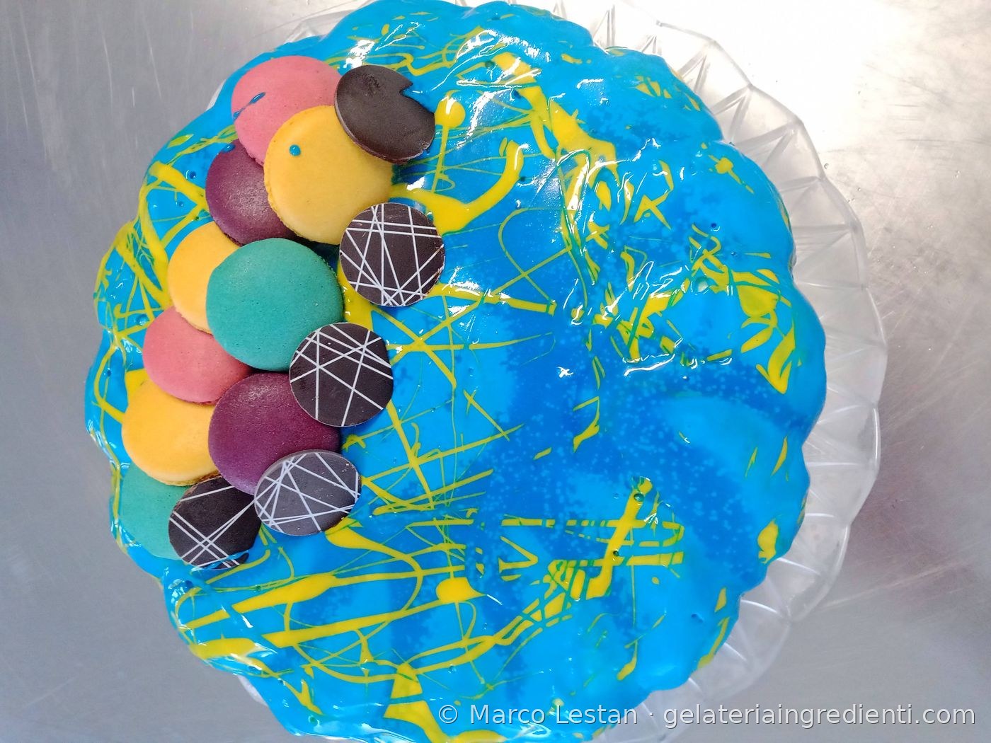 Decorazione torta gelato gialla con farfalle decorative e fiori lilla in pasta di zucchero