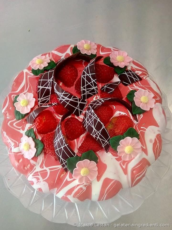 Decorazione torta gelato marmorizzata rosa con fragole, fiori in pasta di zucchero e nastri di cioccolato