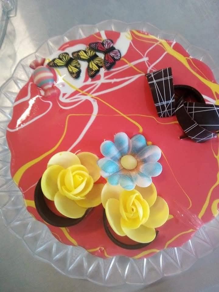 Torta gelato a cuore rossa con fiori in pasta di zucchero e nastri di cioccolato