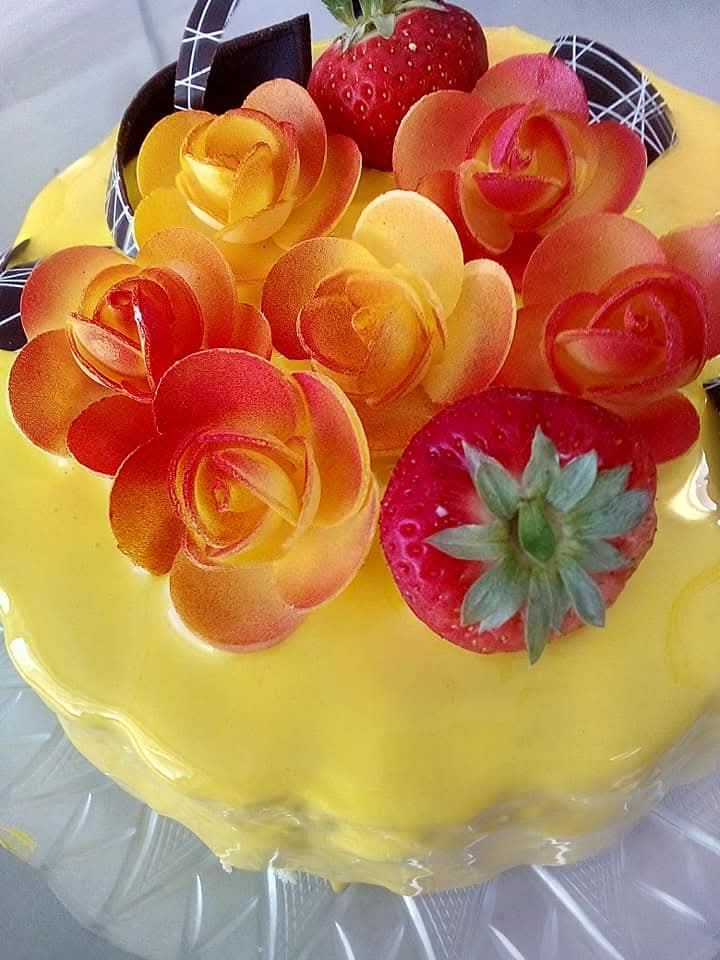 Torta gelato gialla con rose in pasta e fragole fresche
