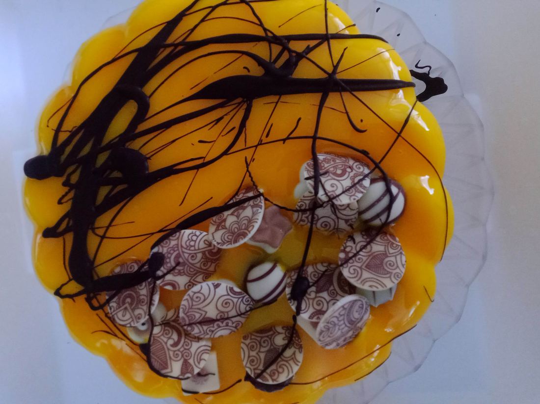 Torta gelato arancione con decori di cioccolato disegnato e ganache