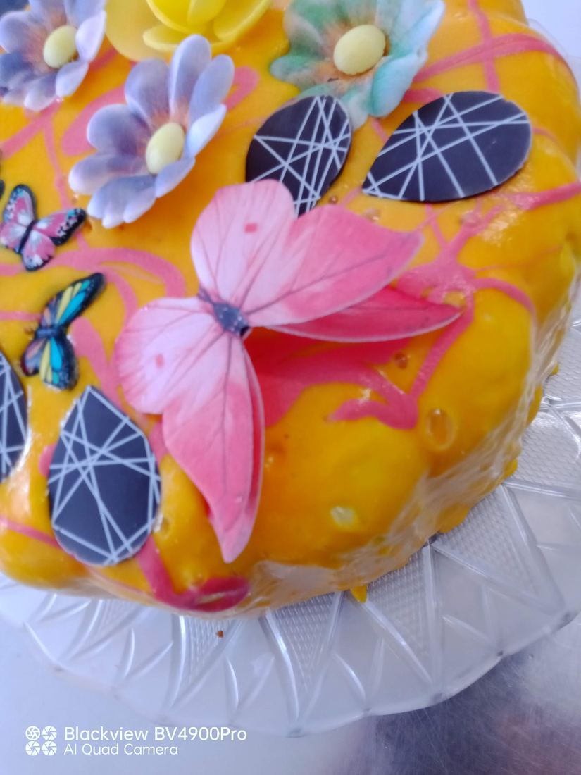 Torta gelato arancione con farfalle e fiori in pasta di zucchero