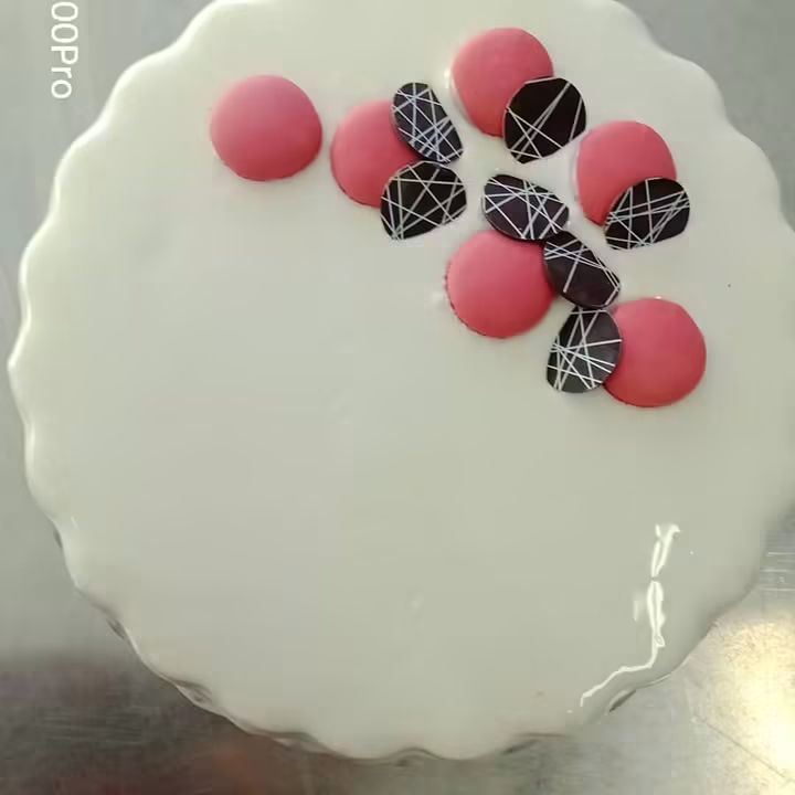 Torta gelato bianca con macaron rosa e dischi di cioccolato decorato