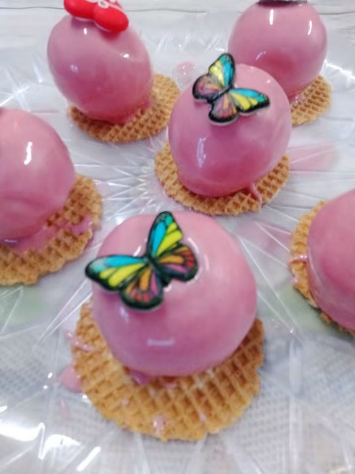 Monoporzioni glassate rosa con decorazioni a farfalla su base di cialda