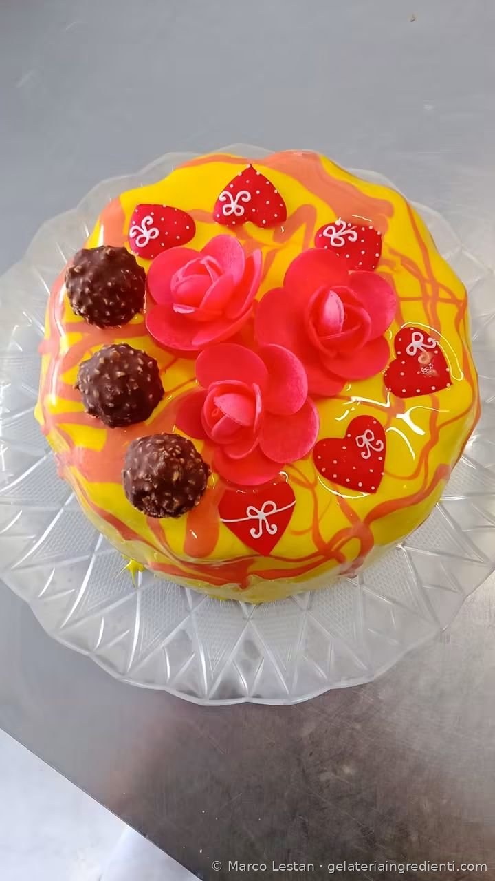 Torta gelato con glassa gialla, rose in pasta di zucchero, cuoricini rossi e praline al cioccolato
