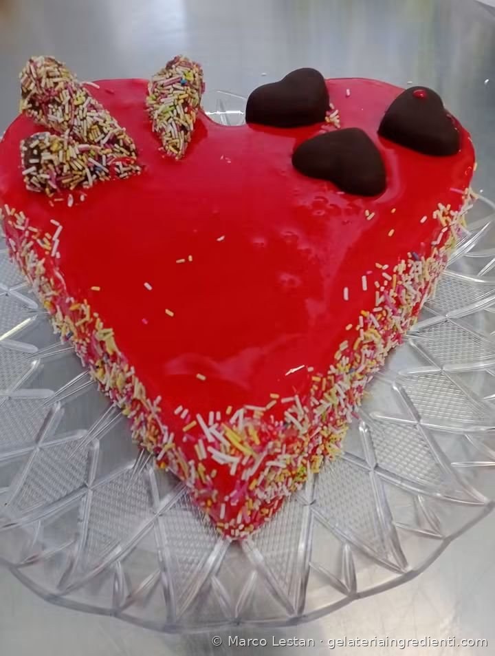Torta gelato a forma di cuore con glassa rossa, codette colorate e cuori di cioccolato