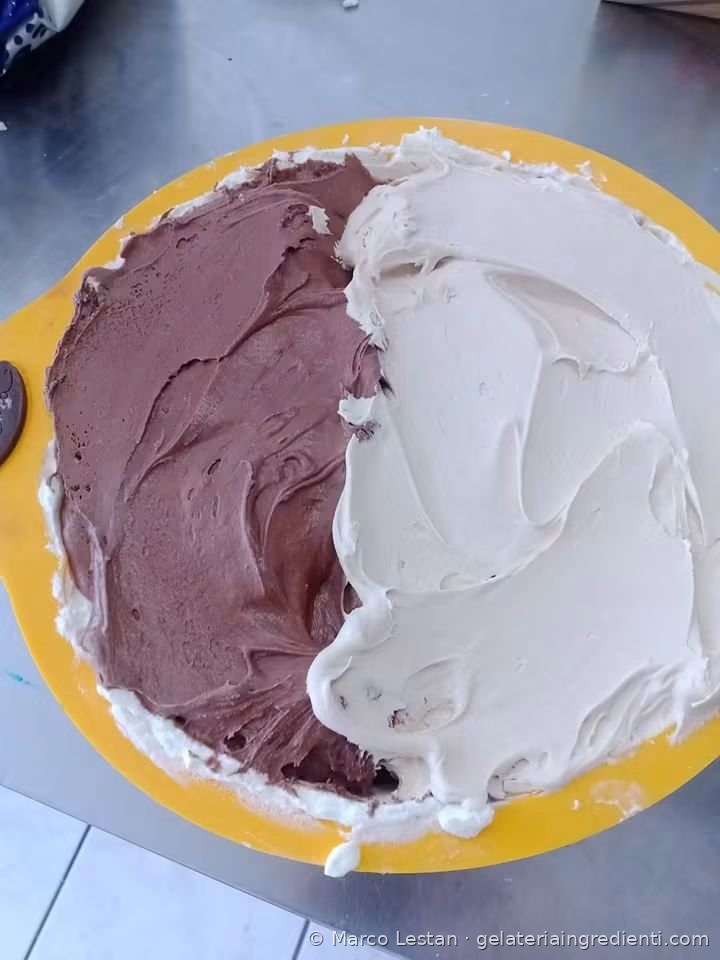 Strato di crema al cioccolato e crema bianca nello stampo in silicone giallo, durante la preparazione