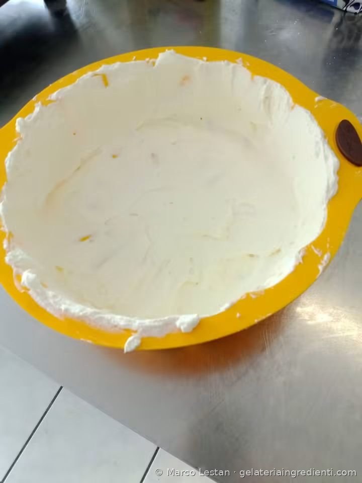 Strato di crema bianca nello stampo in silicone giallo, durante la preparazione